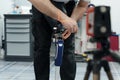 Crop unrecognizable craftsman adjusting and bending modern prosthetic leg at knee section Royalty Free Stock Photo