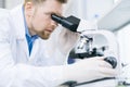 Astonished microbiologist looking at microscope eyepiece Royalty Free Stock Photo