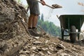 Crop view of young man with shovel moves stones from the road