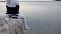 Crop view of young woman standing on the sea rock