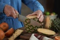 Crop woman cutting pineapple with knife Royalty Free Stock Photo