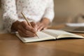 Crop of woman handwrite make notes in notebook