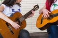 Crop women playing guitars in studio