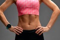 cropped close up body of fit woman wearing shorts and sport top showing slim beautiful stomach and abs in diet fitness