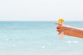 Croped image of woman`s hand holding sunblock spray at the beach