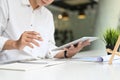 Croped shot young businessman using digital tablet for planing his strategy on white table.