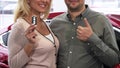 Cropepd shot of a happy couple holding car keys to a newly bought car Royalty Free Stock Photo