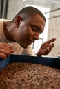 Cropped of barista sniffing roasted coffee beans