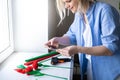 Cropped blonde woman using smartphone to make photo handmade flower paper craft. Social media, instagram, stay home and