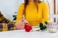 Cropped blurred shot of young man gives flowers to his girlfriend, holds her hands and definitely is going to make a Royalty Free Stock Photo