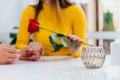 Cropped blurred shot of young man gives flowers to his girlfriend, holds her hands and definitely is going to make a Royalty Free Stock Photo