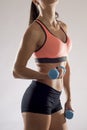 Cropped body close up of young attractive woman in sport clothes holding weight dumbbell