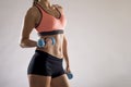 Cropped body close up of young attractive woman in sport clothes holding weight dumbbell