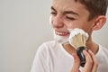 Cropped of boy smearing shaving foam on face