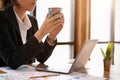 Cropped, Businesswoman holding a coffee cup, sipping morning coffee