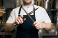 Cropped chef sharpening knife with sharpener on blurred kitchen in restaurant Royalty Free Stock Photo