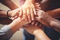 Cropped close of diverse businesspeople putting their hands on top of each other wearing casual clothes