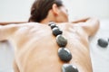 Cropped close up female relaxing in spa salon with hot stones on her back Royalty Free Stock Photo