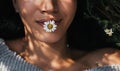 Cropped close-up horizontal shot of brunette young girl with daisy flower in mouth outdoors enjoying nature. Portrait of an Royalty Free Stock Photo