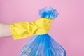 Cropped close up photo of hand holding full garbage bag isolated background