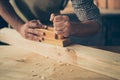 Cropped close up photo of handicraftsman`s hands making a wooden