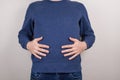 Cropped close-up photo of satisfied happy positive funny funky guy touching holding hands of full stomach isolated grey background