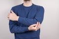 Cropped close-up photo studio portrait of unhappy unsatisfied guy holding touching elbow isolated grey background