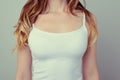 Cropped close up photo of woman`s breast in white t-shirt; she h