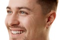 Cropped close-up photo of young man with well-kept skin and healthy smile looking away against white studio background. Royalty Free Stock Photo