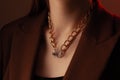 Cropped close up portrait of young woman with perfect silky skin, demonstrating golden jewelry chain with medallion on