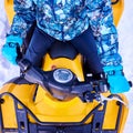 Cropped close-up snapshot of person in blue winter suit sitting on yellow ATV bike in winter Royalty Free Stock Photo