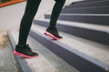 Cropped close up of woman legs in sportswear, black and pink sneakers doing sport exercises, climbing on stairs outdoors Royalty Free Stock Photo