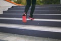 Cropped close up of woman legs in sportswear, black and pink sneakers doing sport exercises, climbing on stairs outdoors Royalty Free Stock Photo