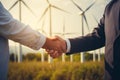 Cropped closeup of a handshake between two businessmen with a wind turbines background Royalty Free Stock Photo