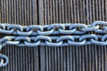 A Cropped Closeup Image Of A Linked Chain. Metal Chain Over Wooden Background.