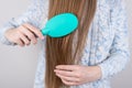 Cropped closeup photo of girl caring about her silky fresh smooth pure good strong hair using hairbrush isolated grye background