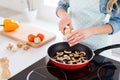 Cropped closeup photo of house wife hands add spices frying pan grill mushrooms meal cooking tasty dinner lunch