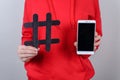 Cropped closeup photo of people person holding demonstrating showing black crossed hashtag in hand and white smart phone isolated