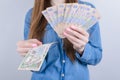 Cropped closeup photo of rich wealthy lady businesswoman holding pile stack of money in hands grey background
