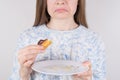 Cropped closeup photo of sad woman havinf regret of eating too much tasty dessert holding white plate with leftovers in hands Royalty Free Stock Photo