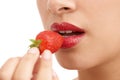 Bright red allure. Cropped closeup shot of a young woman with red lips eating a strawberry. Royalty Free Stock Photo