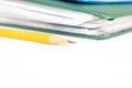 Cropped colorful folders with documents and bills and a yellow pencil on white table with copy space Royalty Free Stock Photo