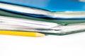 Cropped colorful folders with documents and bills and a yellow pencil on white table with copy space Royalty Free Stock Photo