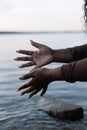Cropped dark skin woman gently touching and splashing fresh cool blue clear water in sea or river by hands. Copy space Royalty Free Stock Photo