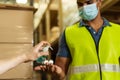 Engineer worker using alcohol based hand sanitizer gel for washing hand while working in factory warehouse in face mask