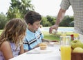 Cropped Father Pouring Syrup By Children