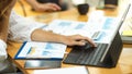 Cropped, female auditor working on tablet with accounting paperworks