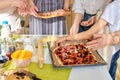 Cropped female hands adding ingredients to pizza, prepading tasty pizza for whole family Royalty Free Stock Photo