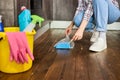 Cropped female hands sweeping Dust with brush and dustpan, holding broom and sweeping floor, collecting dust into