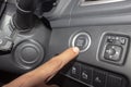 Cropped finger pressing start button in car while test driving